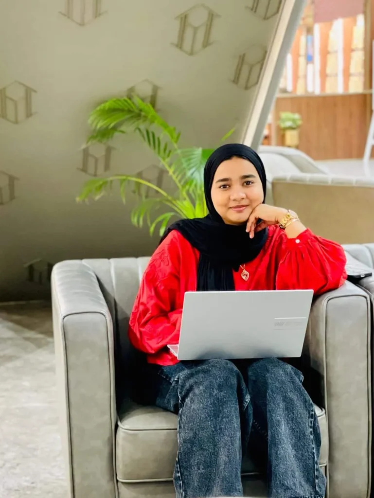 A photo of a digital marketing specialist in dubai uae sitting in couch witrh laptop